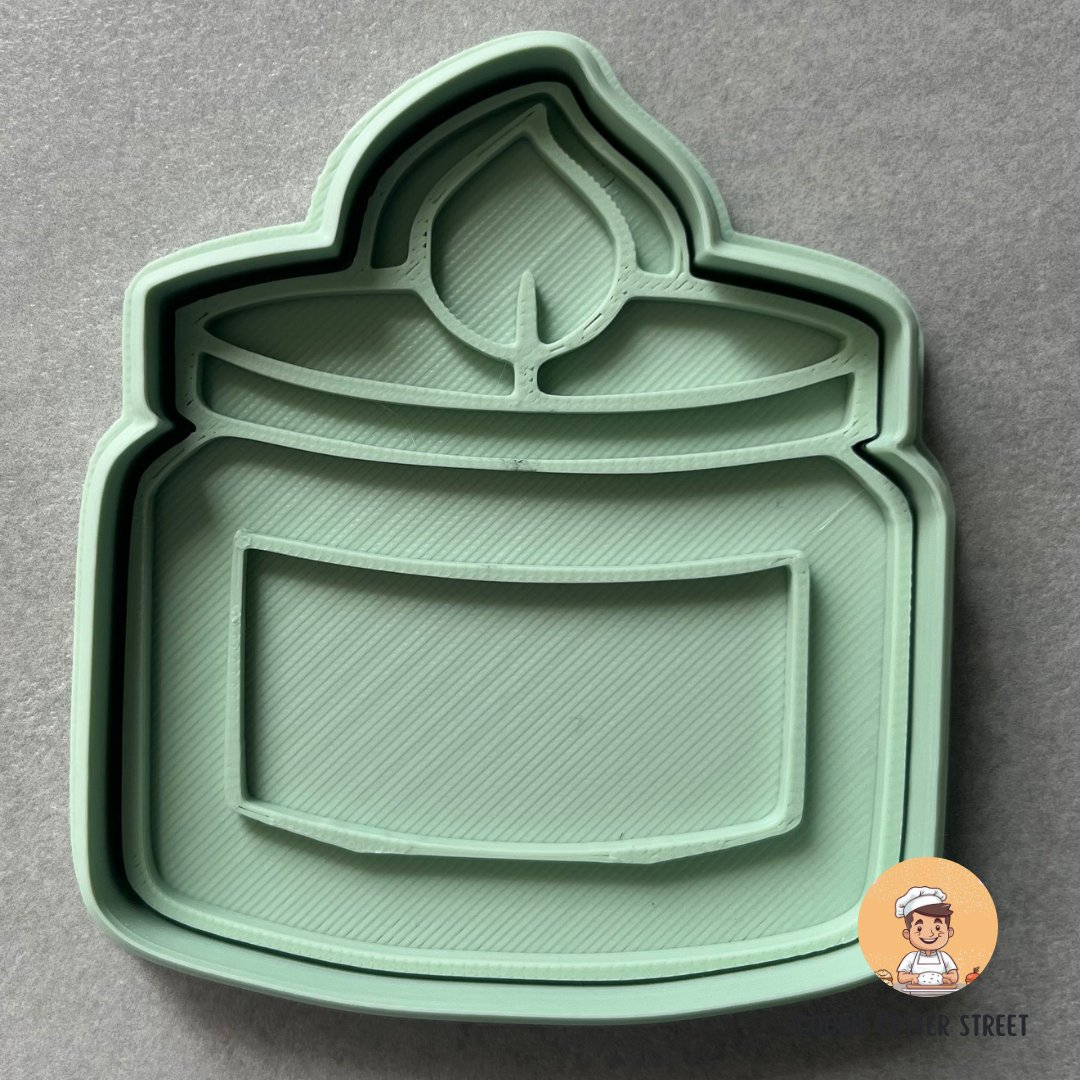 Green cookie cutter shaped like a candle jar