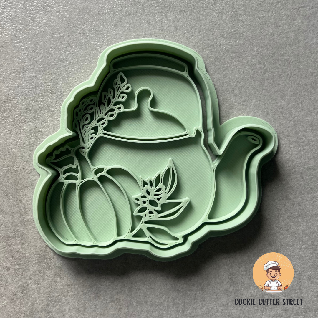 Green cookie cutter with pumpkin design on a grey background