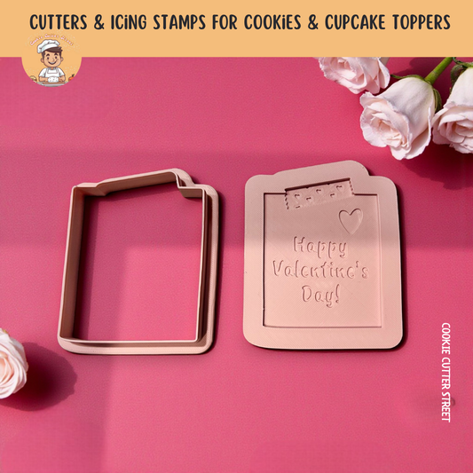 Cookie cutters with 'Happy Valentine's Day!' design on a pink background with roses.
